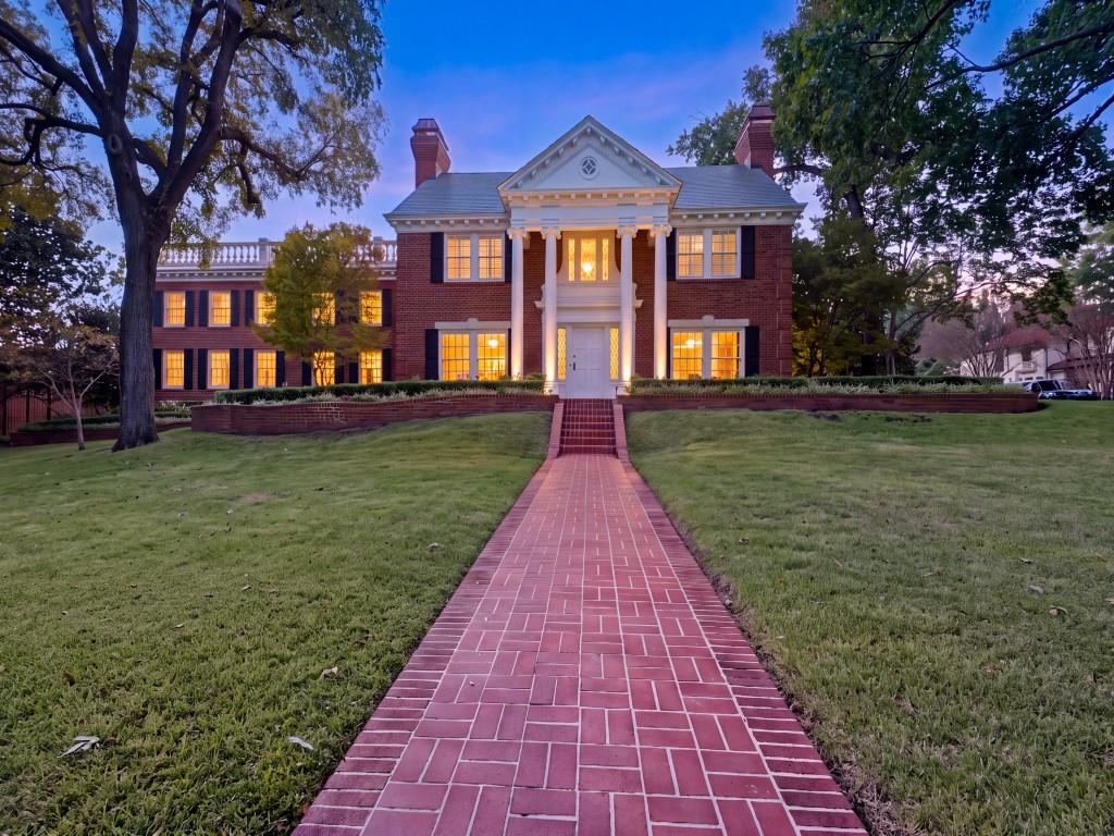 Classic brick colonial exterior featuring a prominent two-story portico, herringbone-patterned masonry walkway, tiered landscape retaining walls, and multi-pane windows with decorative shutters Classic brick colonial exterior featuring a prominent two-story portico, herringbone-patterned masonry walkway, tiered landscape retaining walls, and multi-pane windows with decorative shutters