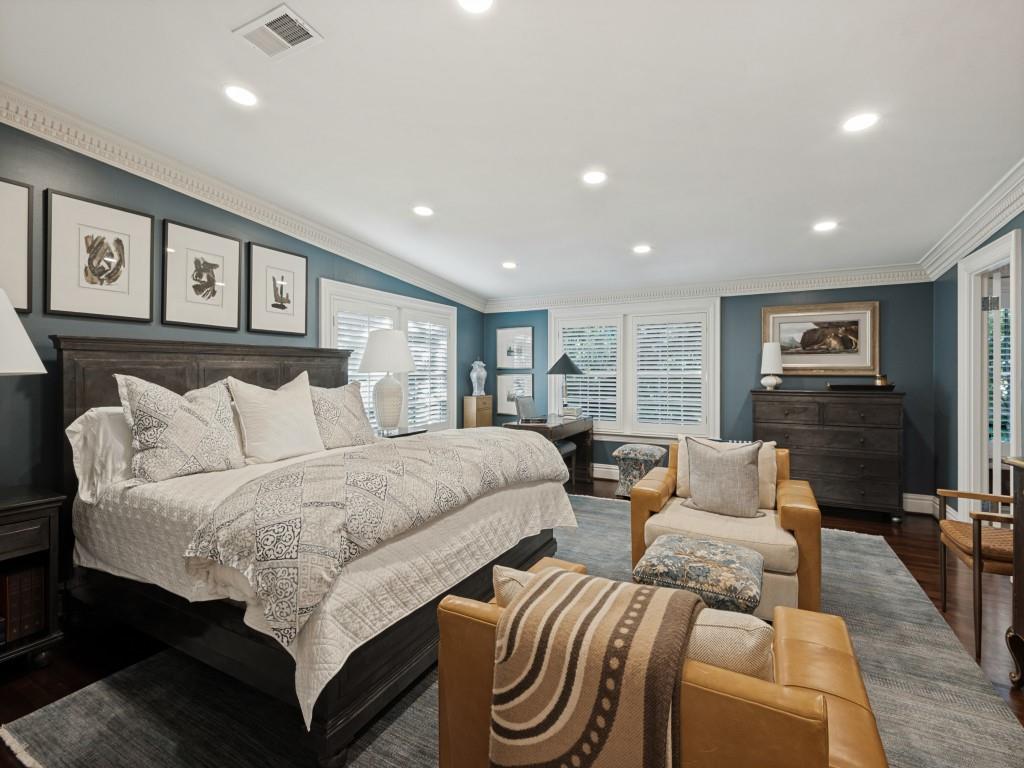 Spacious room featuring crown molding, recessed lighting, dark-toned walls, wood-finish flooring, and multi-pane shutters