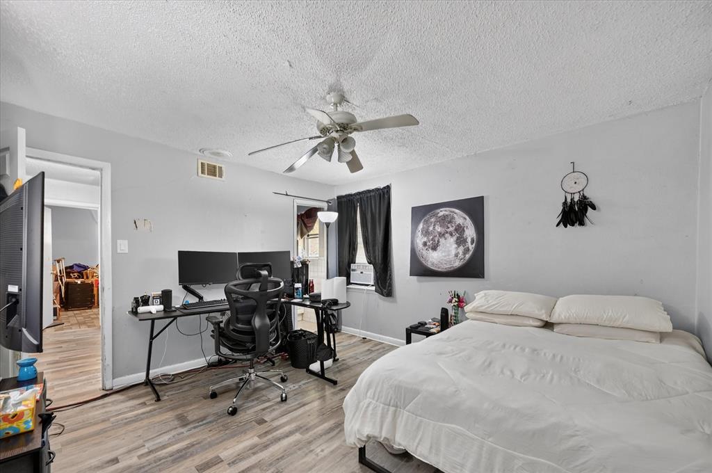 Wood-finish flooring with a neutral wall color and a ceiling fan