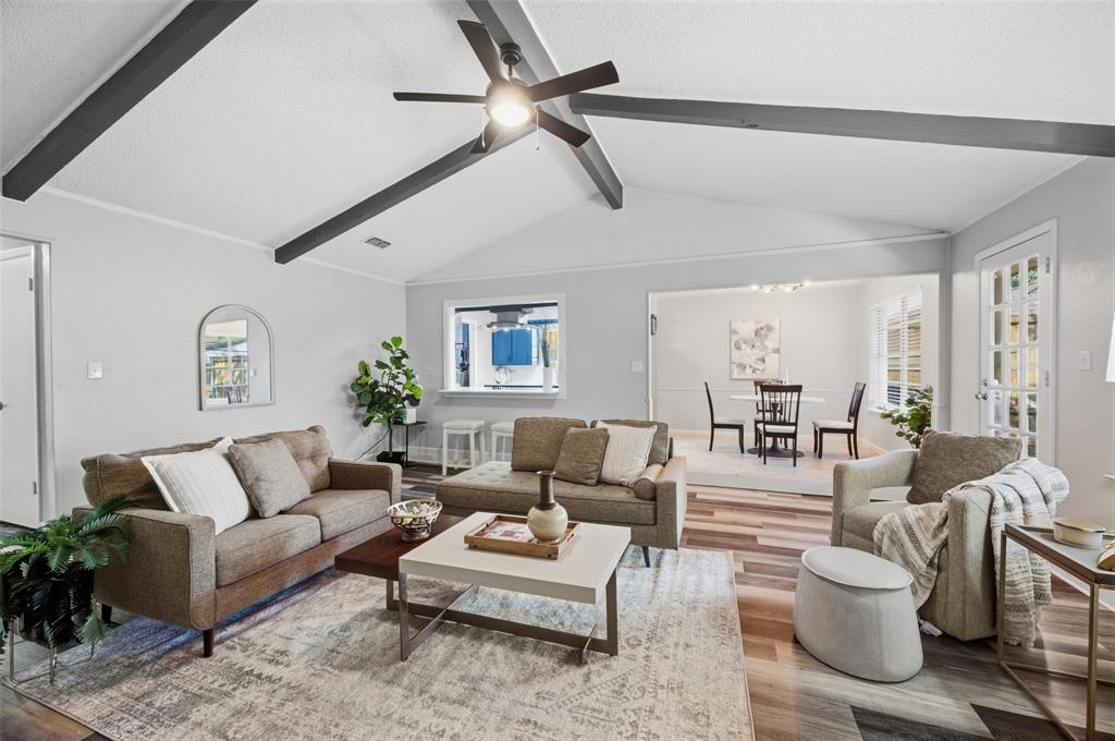 Vaulted ceiling with exposed beams, wood-finish flooring, recessed lighting, and a ceiling fan