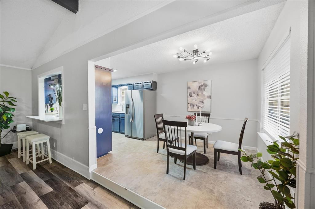 Wood-finish flooring, pass-through window with counter seating, recessed entryway, contemporary light fixture, and horizontal blinds