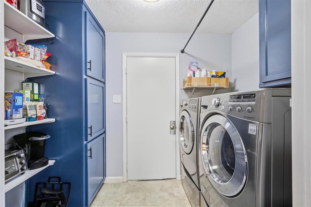 Built-in shelving, blue cabinetry with dark hardware, and a hanging rod