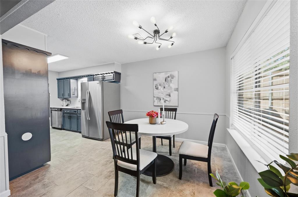 Dining area with a contemporary sputnik-style light fixture, a window with horizontal blinds, and a chair rail
