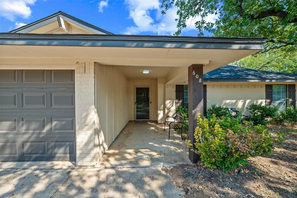 Covered entryway with recessed lighting, integrated garage, and a brick and siding exterior