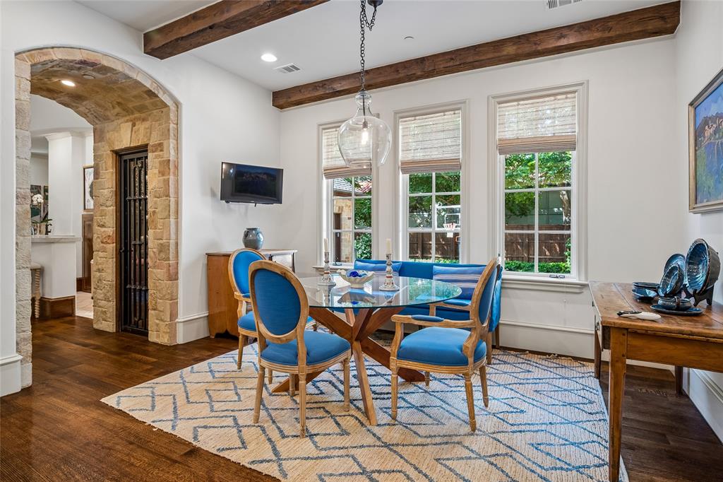 Wood-finish flooring, exposed wood ceiling beams, stone archway, and three large windows