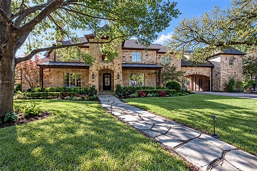 Stone exterior with arched entry, complementing stone walkway, and mature landscaping Stone exterior with arched entry, complementing stone walkway, and mature landscaping
