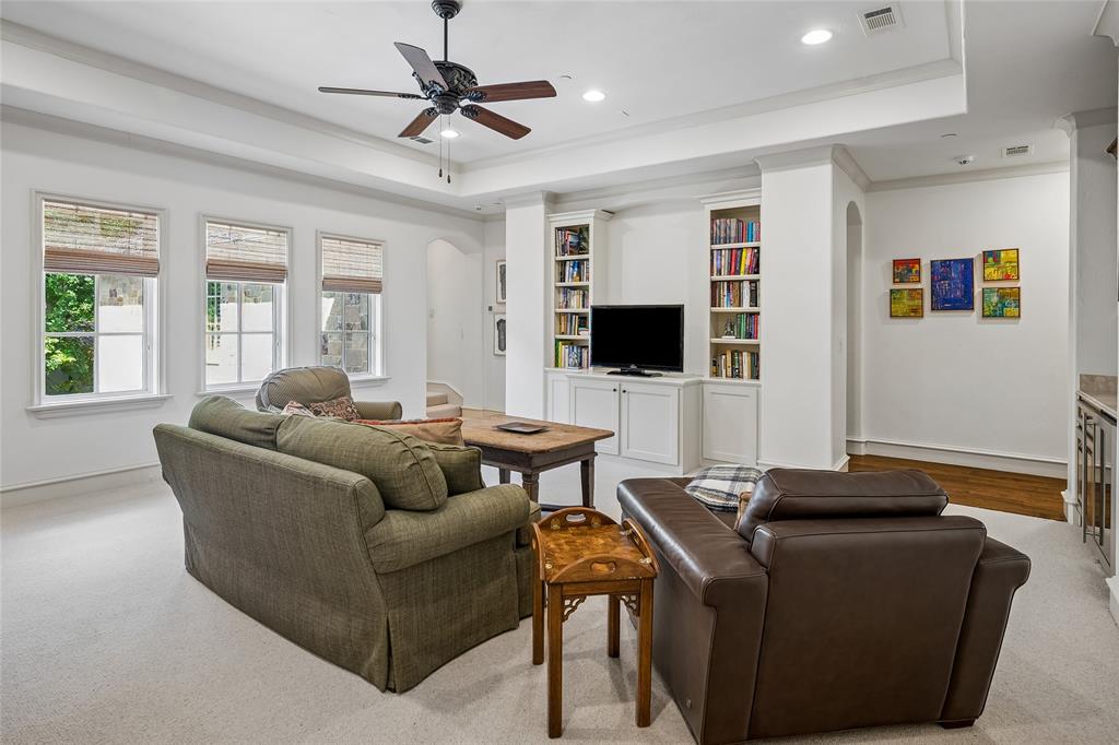 Second floor living area featuring a tray ceiling, recessed lighting, ceiling fan, built-in shelving, and multiple windows
