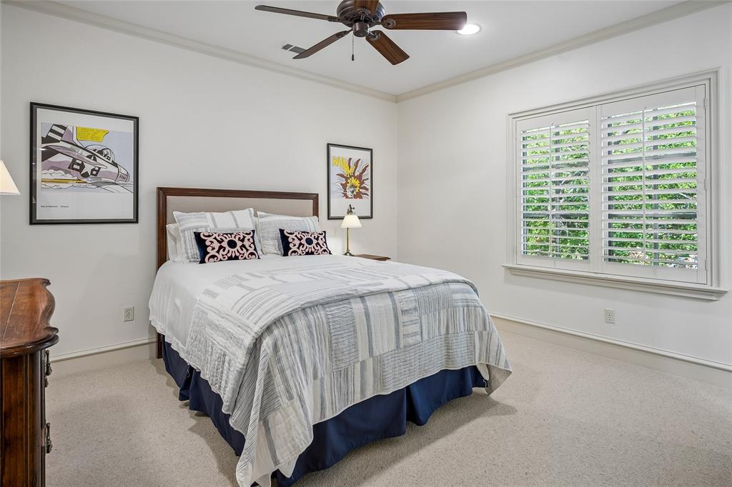 Bedroom suite #5 Textured carpet flooring, crown molding, a ceiling fan with light, and a window with plantation shutters