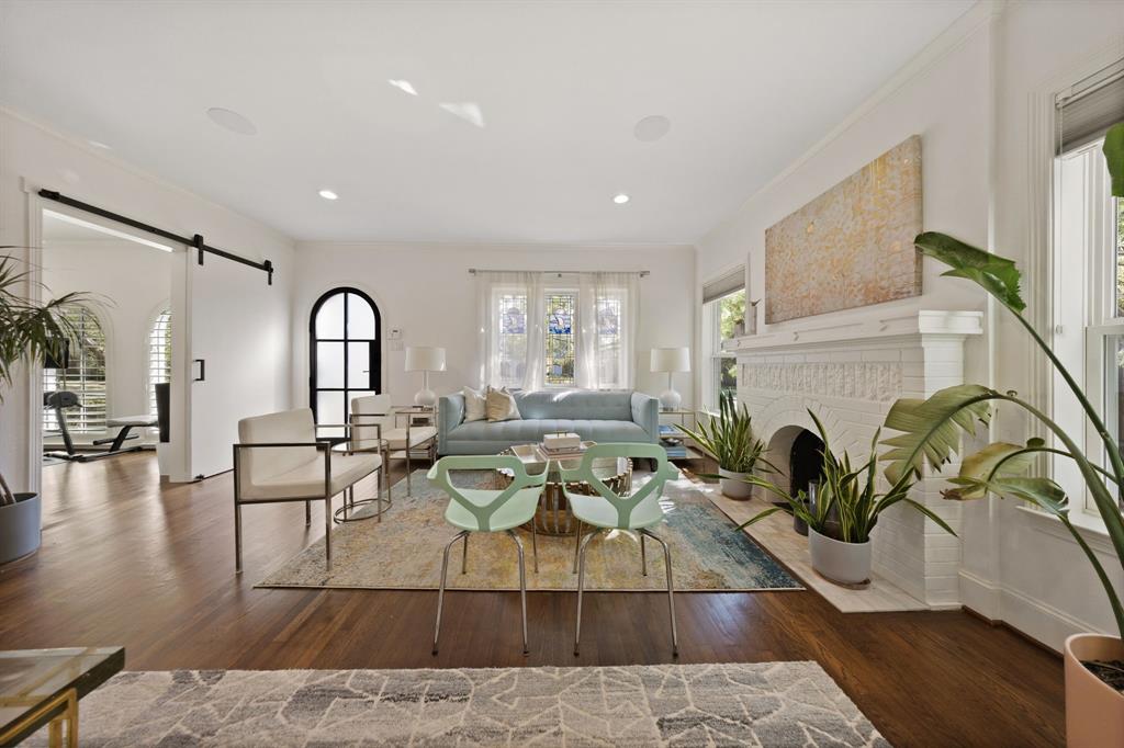 Hardwood flooring, decorative fireplace, recessed lighting, double windows, and barn door entry