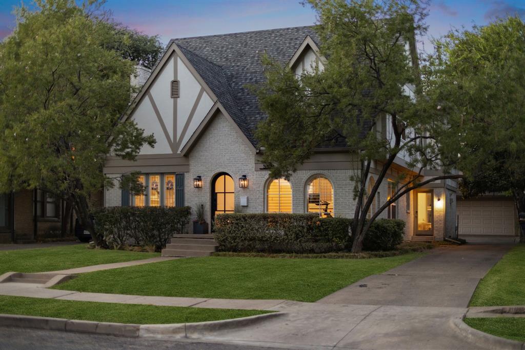 Tudor-style facade with a gabled roof, arched entryway, and stone exterior