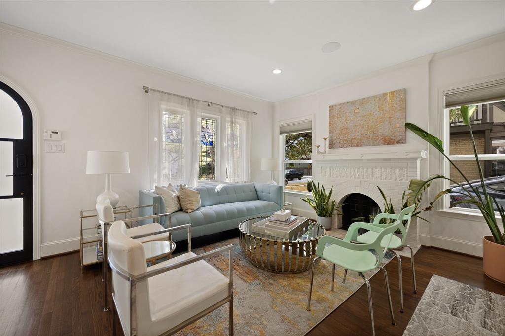 Hardwood flooring, decorative fireplace, recessed lighting, arched entryway, and multiple windows