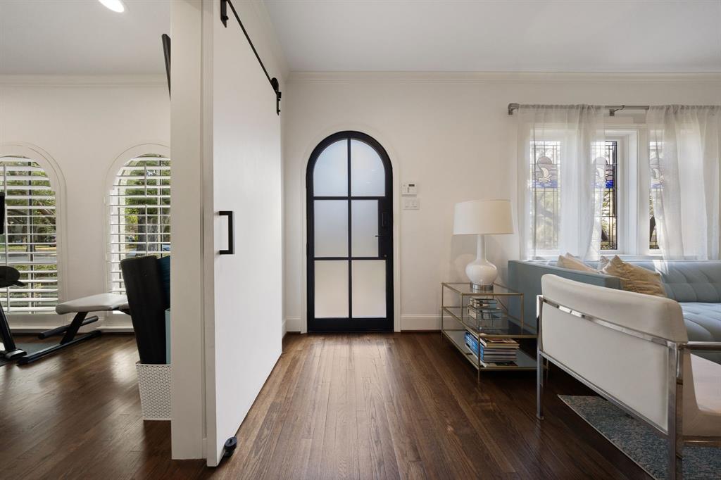Rich wood-finish flooring throughout, complemented by a modern barn door