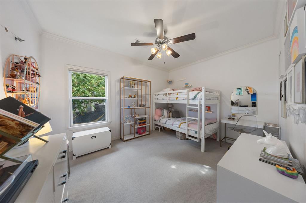 Vaulted ceiling featuring a ceiling fan, window with white trim, and light-toned carpet flooring