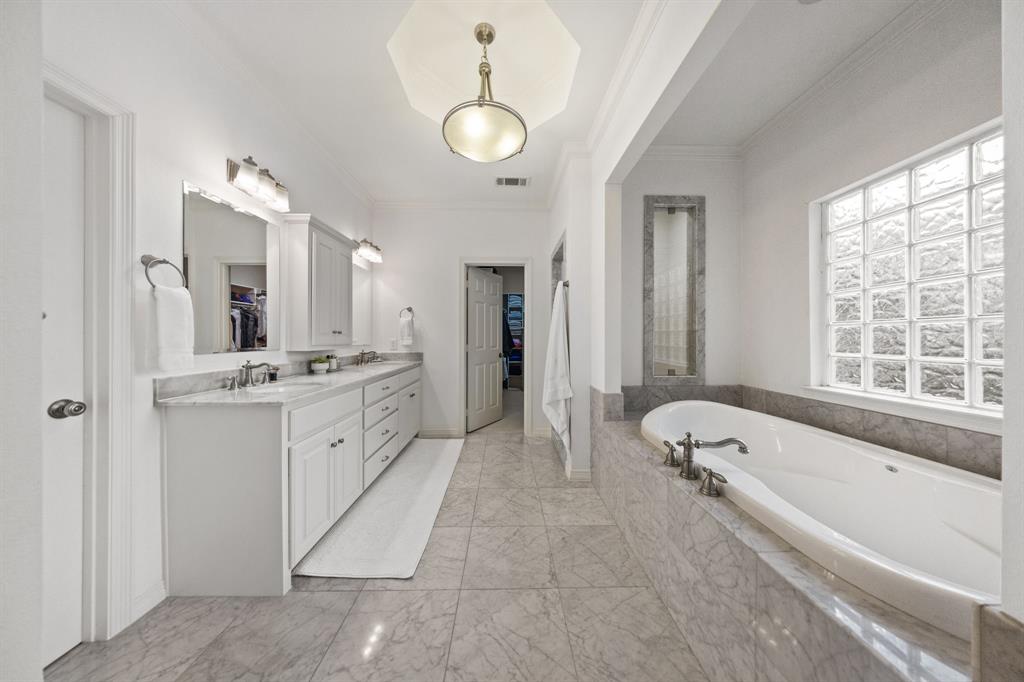 Double vanity with white cabinetry, integrated sinks, and polished chrome fixtures