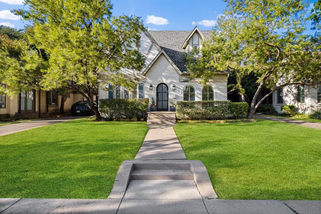 Tudor Revival style exterior with a gabled roof, arched front door, and symmetrical arched windows