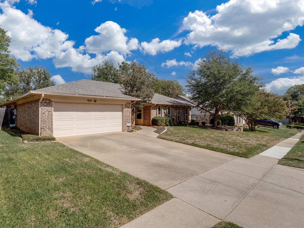 Single-story brick exterior featuring a multi-gable roofline, two-car garage, and concrete driveway