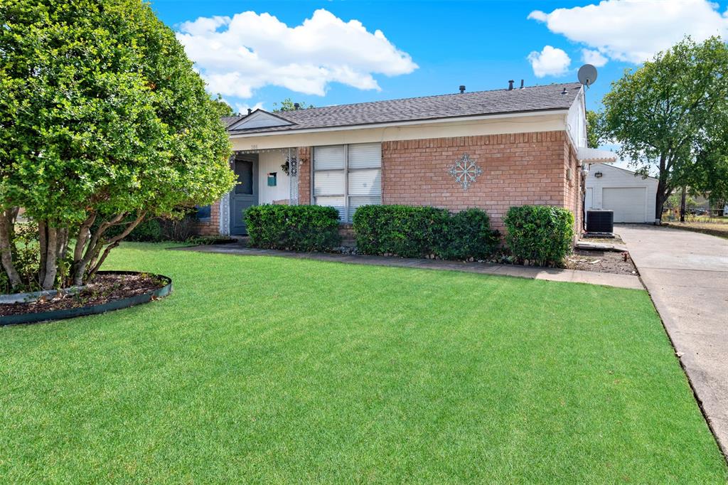Ranch-style house with a front yard, cooling unit, and a garage Ranch-style house with a front yard, cooling unit, and a garage
