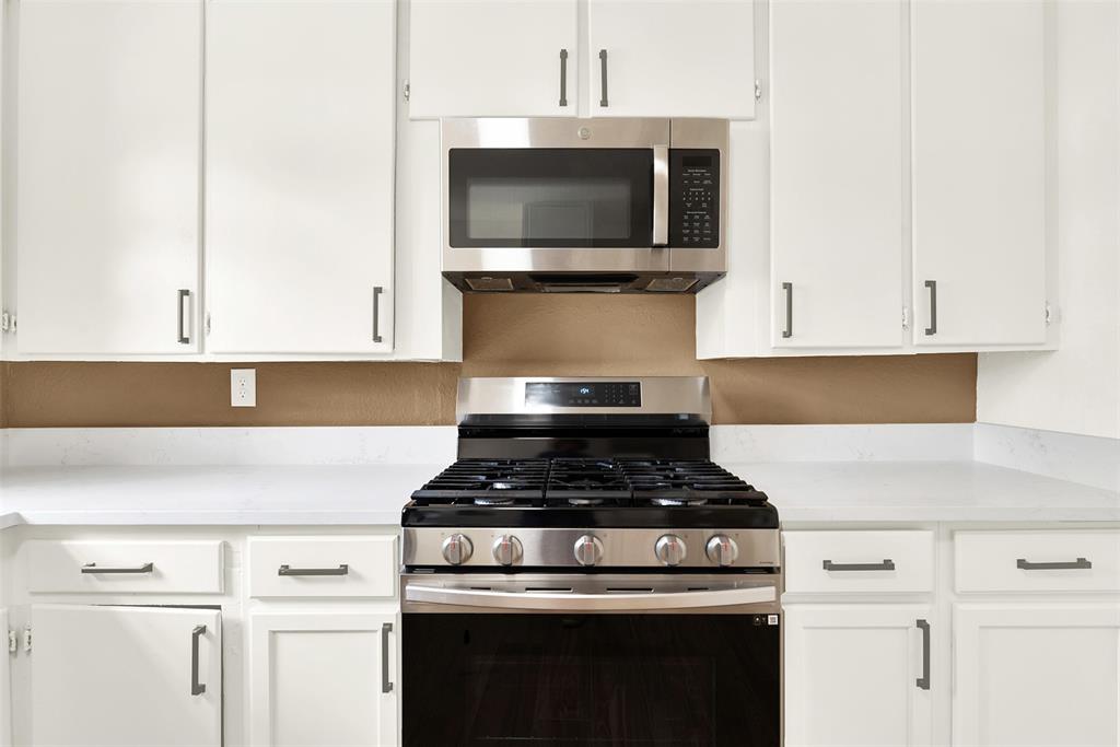 Kitchen with white cabinetry and stainless steel appliances
