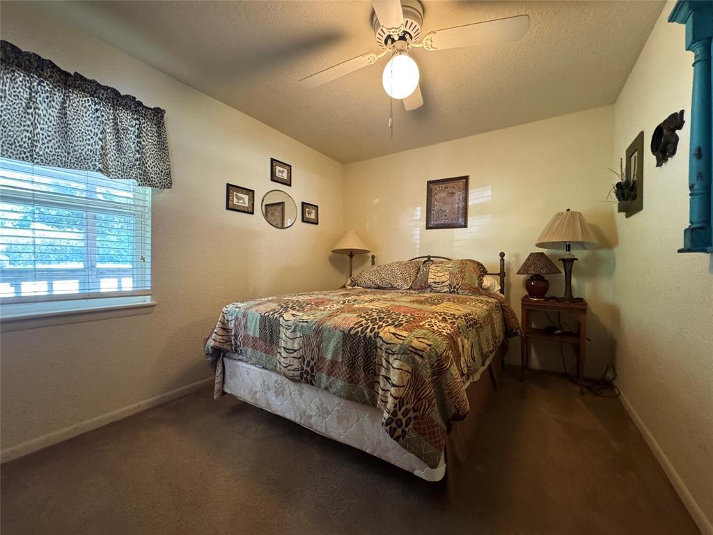 Wall-to-wall carpeted flooring, window with blinds, and ceiling fan with integrated lighting