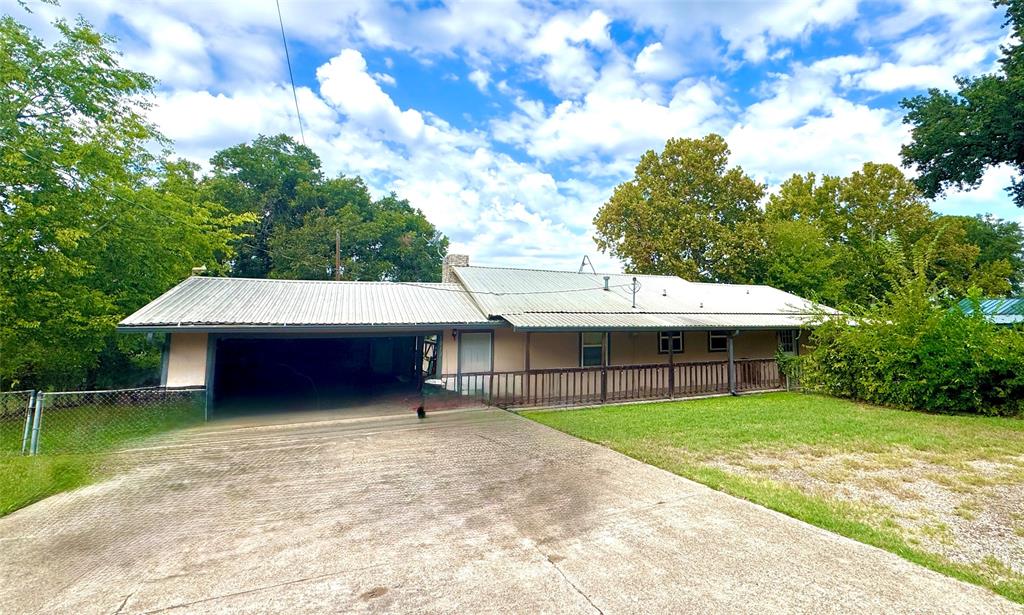 Extended driveway leading to a covered carport