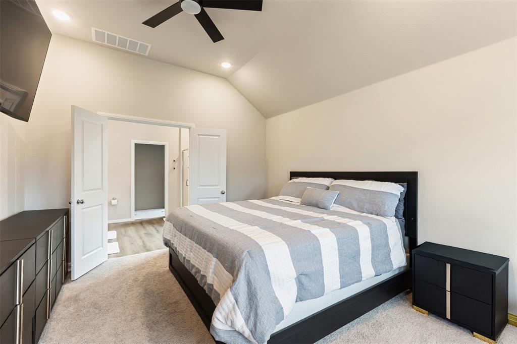 Bedroom with lofted ceiling, recessed lighting, ceiling fan, and light carpet