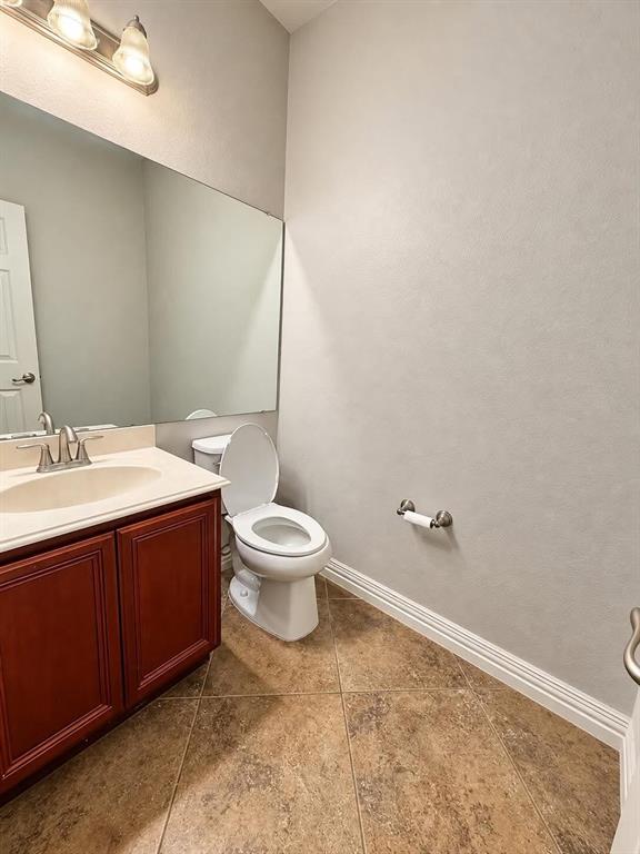Vanity with wood-finish cabinetry, integrated sink, and brushed nickel faucet