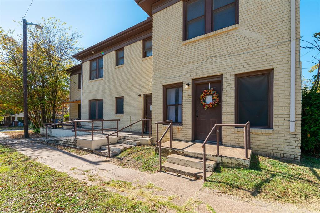 Brick exterior with multiple entryways, concrete stairs, and handrails