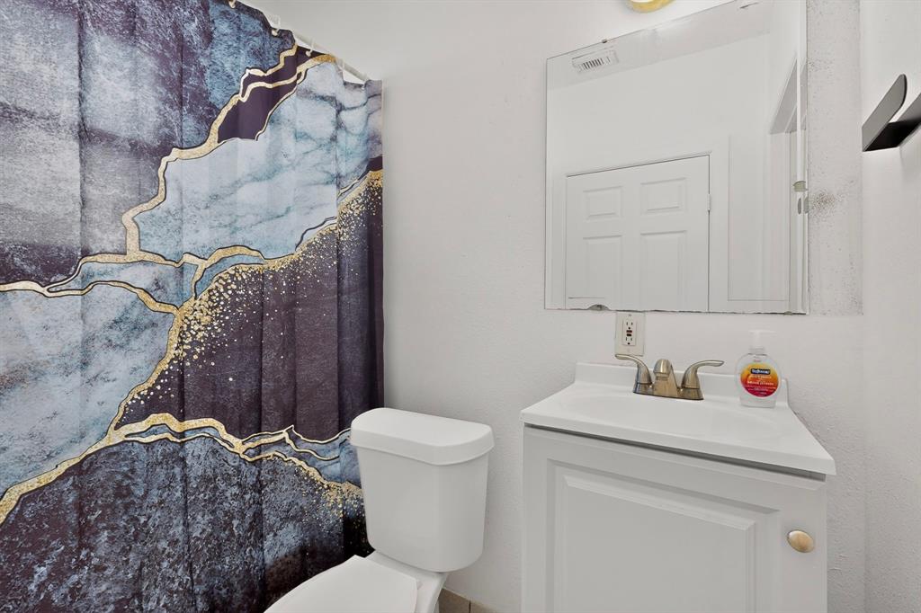 White vanity with integrated sink, wall-mounted mirror, and a two-door cabinet