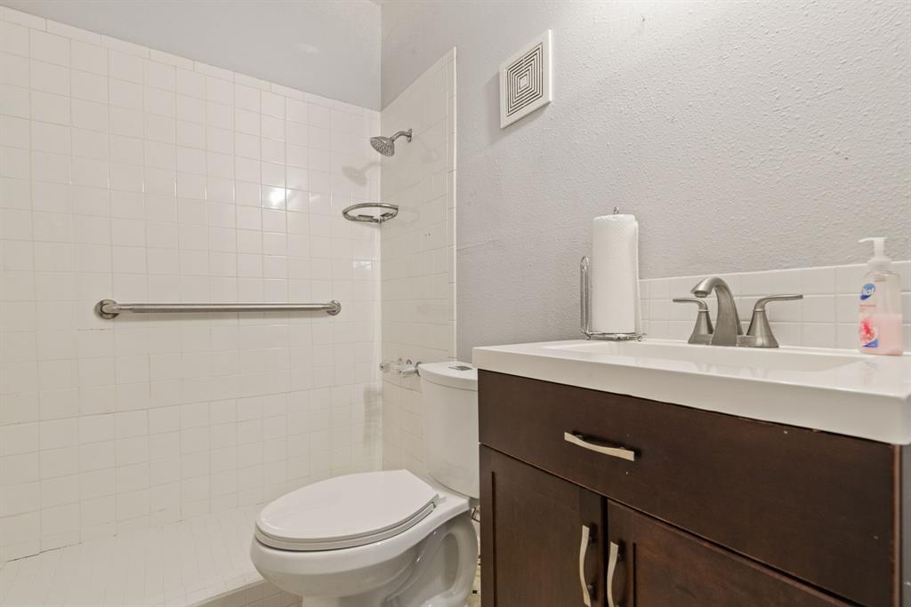 White tiled shower surround with grab bar