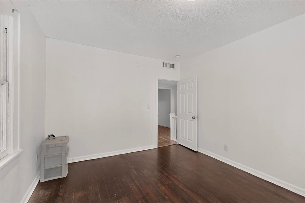 Hardwood flooring, painted white walls, recessed lighting, and a white interior door