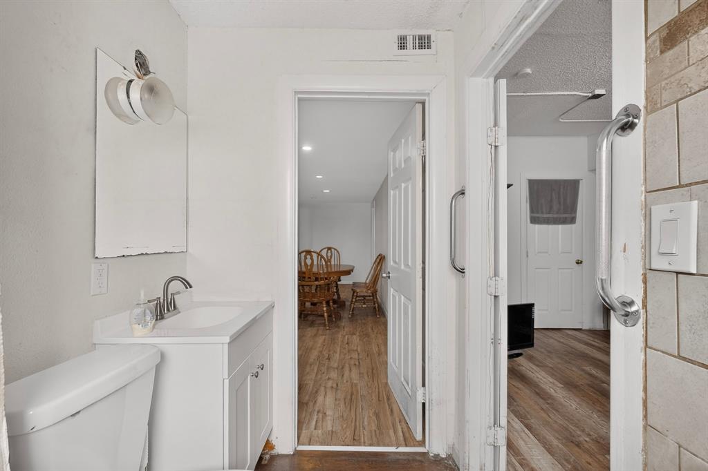 White vanity with integrated sink, chrome faucet, and white toilet