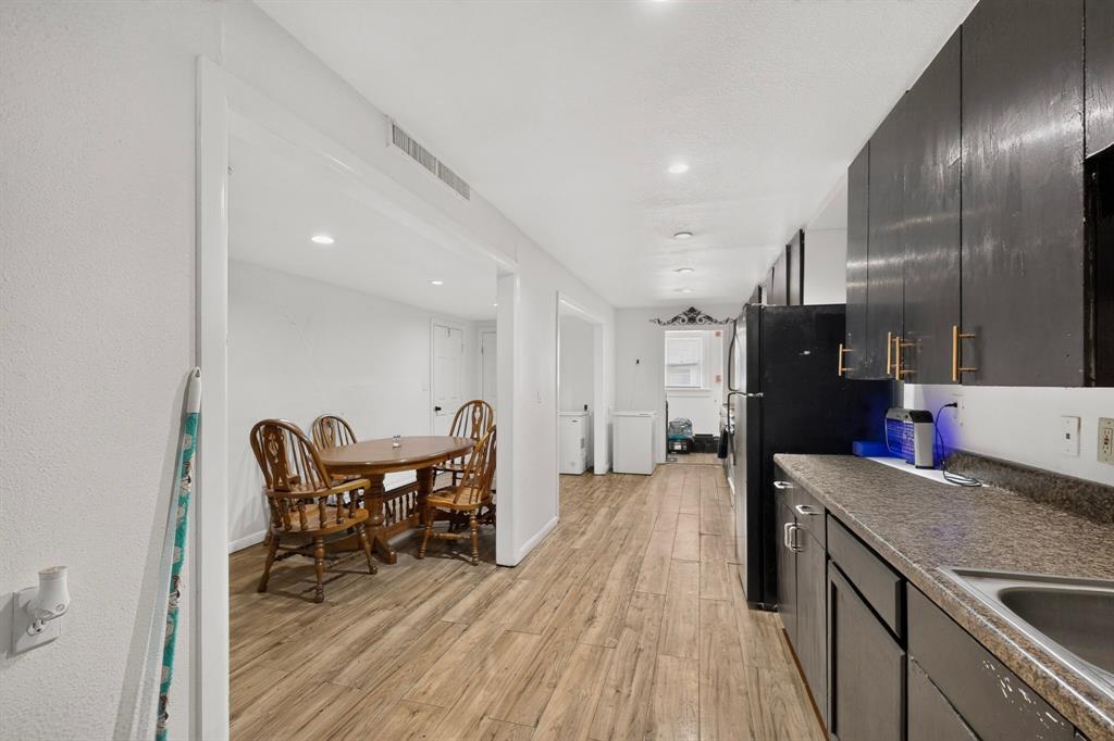 Kitchen featuring dark cabinetry with gold-toned hardware, a stainless steel sink, and speckled countertops