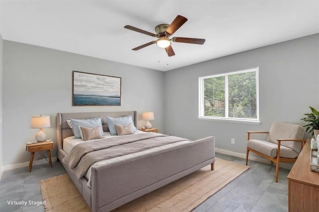 Room featuring light gray wall paint, gray tile flooring, a single window, and a ceiling fan with integrated lighting