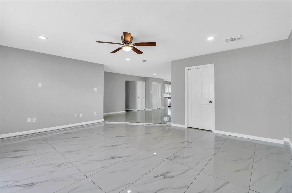 Spacious interior dining area room featuring large format tile flooring, light gray wall paint, recessed lighting, a ceiling fan, and white trim throughout