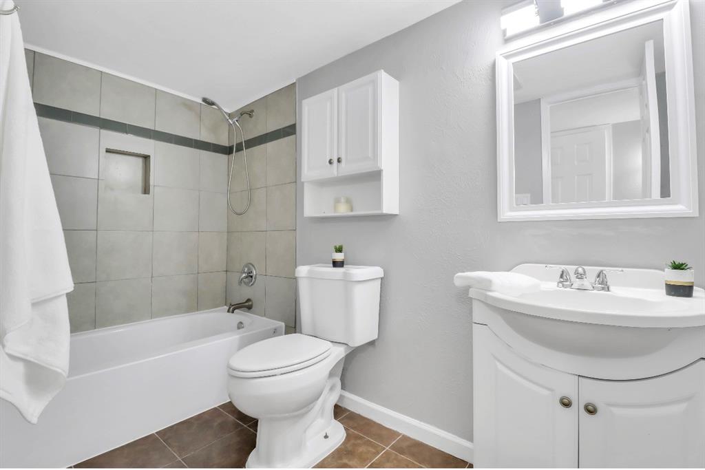 Full bathroom featuring a tub-shower combination with tiled surround, a recessed shower niche, and a wall-mounted shower head