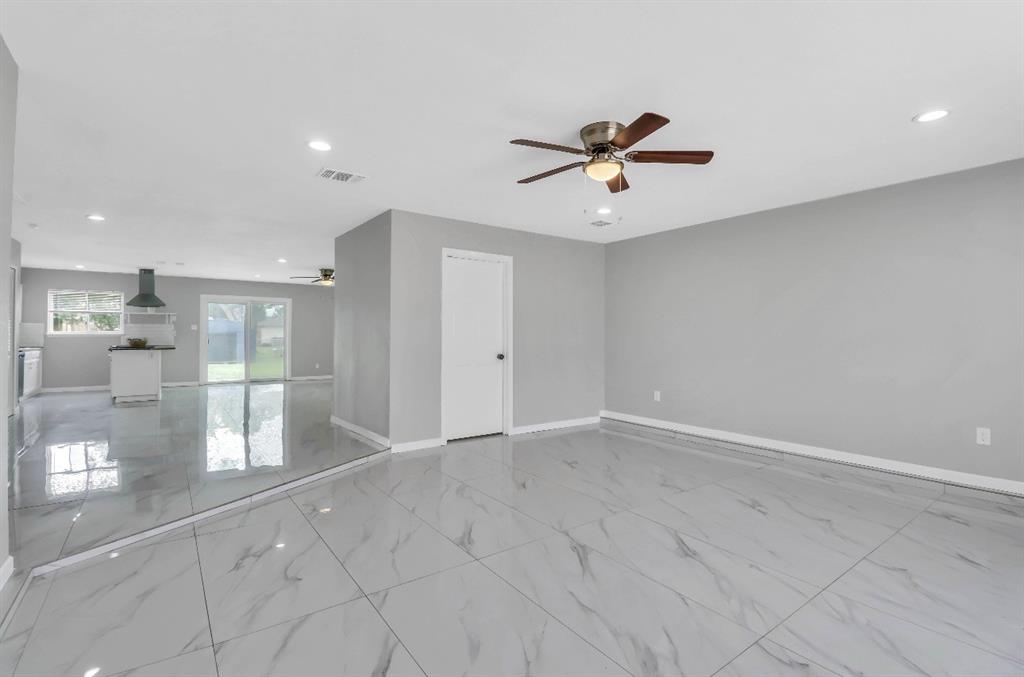 Spacious second family room featuring large format marble-look tile flooring, recessed lighting, and a ceiling fan
