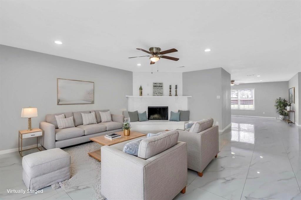Spacious living area featuring light gray walls, recessed lighting, and a ceiling fan