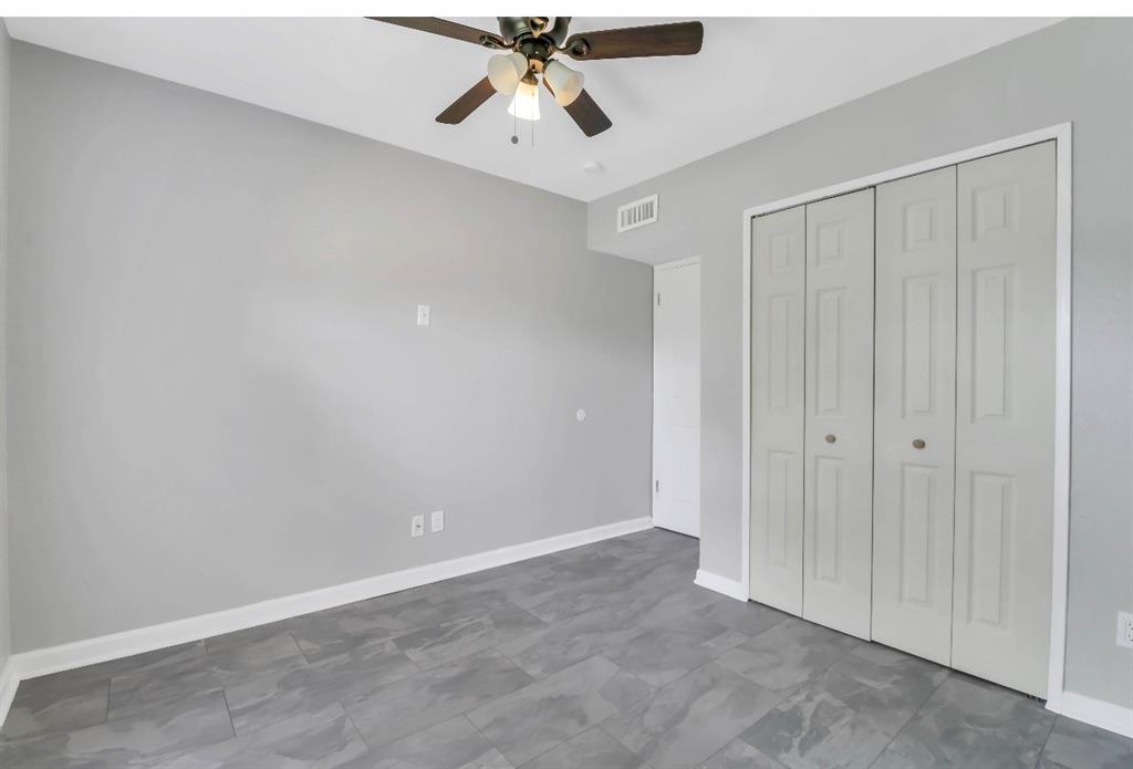 Room featuring grey walls, contemporary tile flooring, and a ceiling fan