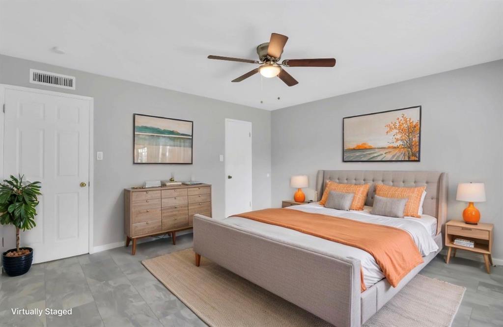 Bedroom with light gray walls, gray tile flooring, and a ceiling fan with integrated lighting