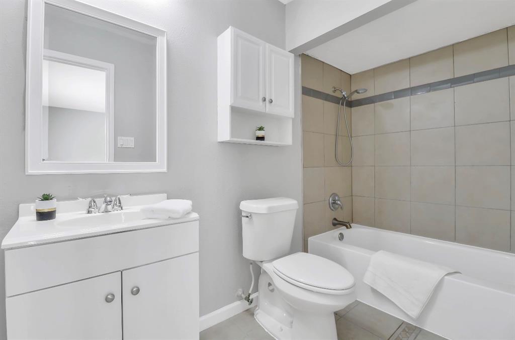Bathroom featuring a white vanity with an integrated sink, framed mirror, and chrome fixtures