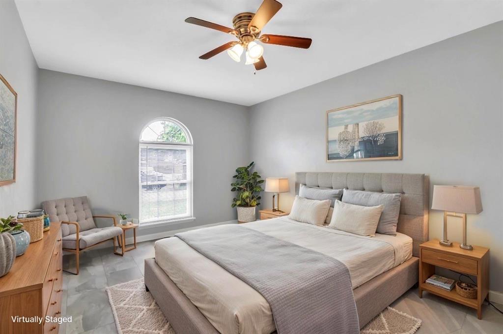 Vaulted ceiling with a ceiling fan, arched window, grey wall paint, grey flooring, and a built-in bed frame