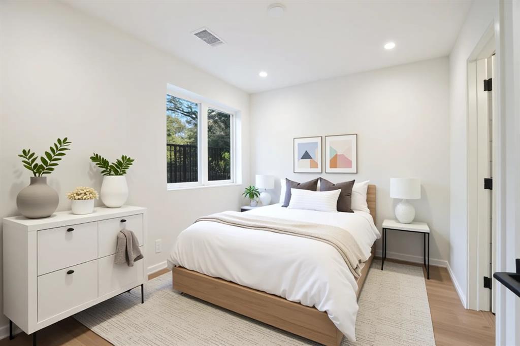 Recessed lighting illuminates this bright room with light wood-finish flooring