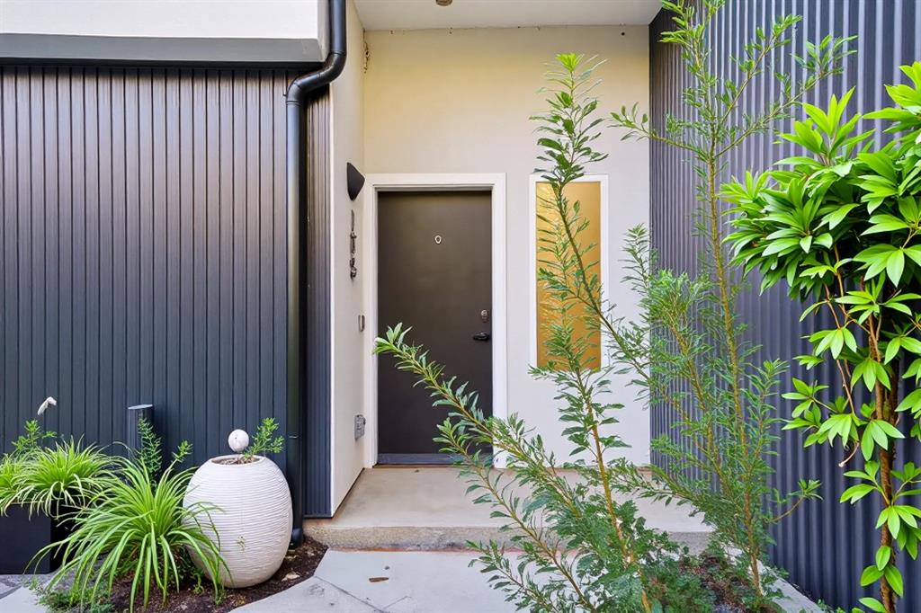 Contemporary exterior with dark vertical siding, contrasting light stucco, and a prominent dark entry door