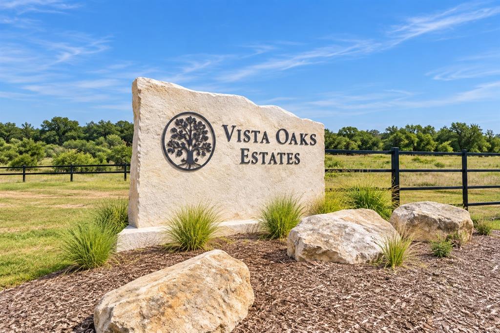 Stone monument sign featuring etched lettering and an ornamental tree emblem