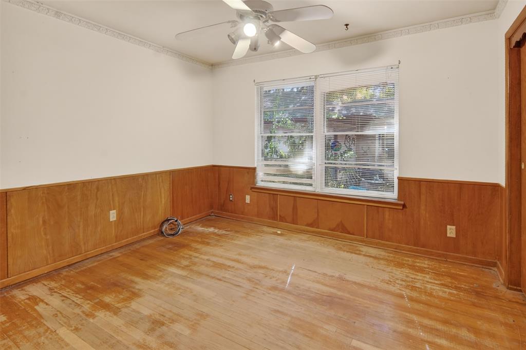 Wood-finish flooring, wood paneling, and a ceiling fan with integrated lighting