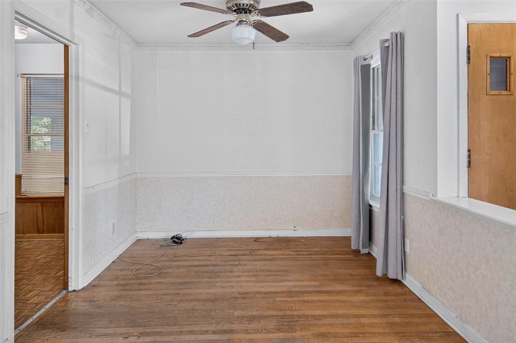 Hardwood flooring, ceiling fan, wall paneling, window with natural light