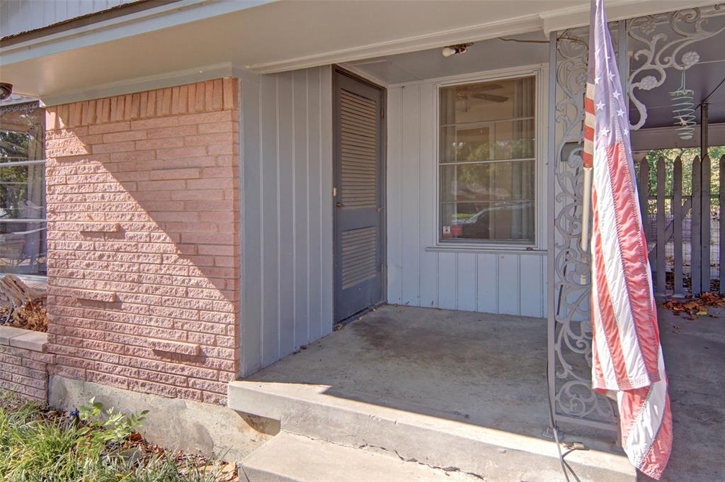 Brick facade with vertical siding, covered concrete porch, and decorative wrought iron column Brick facade with vertical siding, covered concrete porch, and decorative wrought iron column