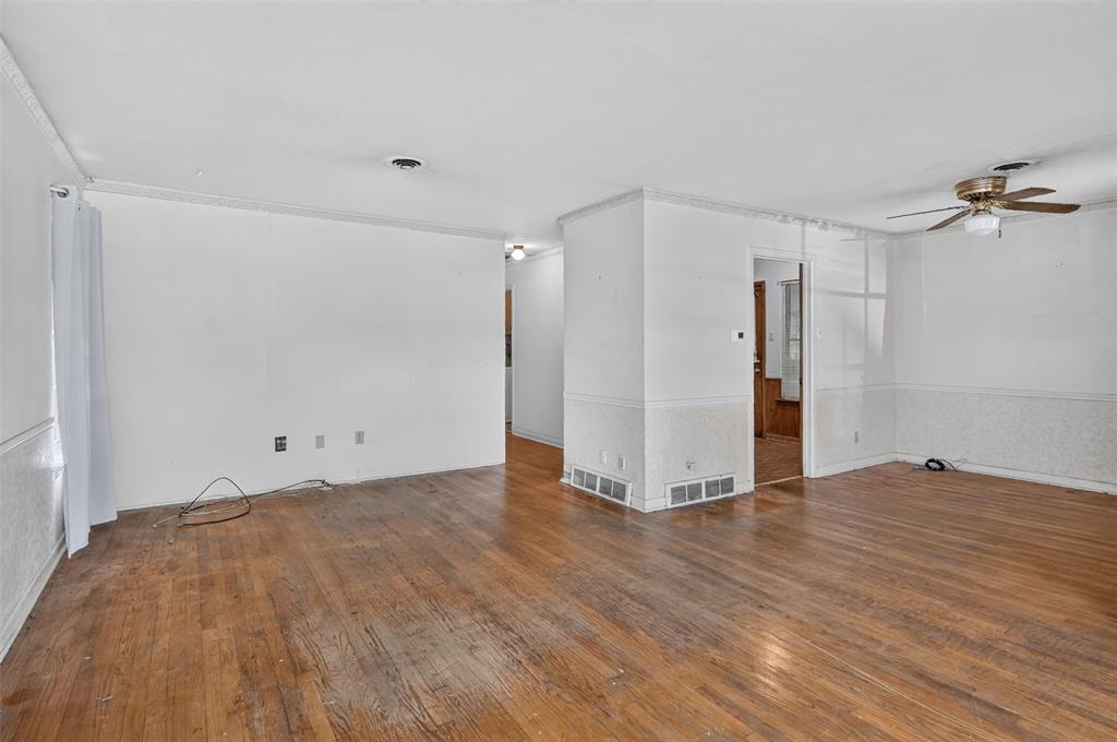 Hardwood flooring, crown molding, ceiling fan, and white walls