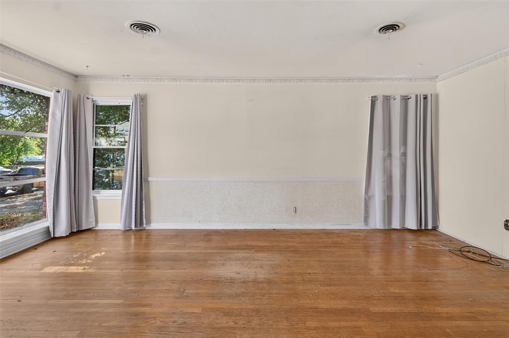 Wood-finish flooring with multiple windows and crown molding Wood-finish flooring with multiple windows and crown molding