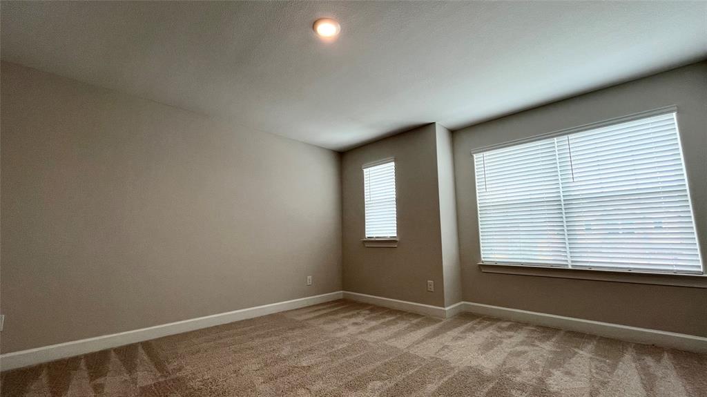 Carpeted flooring, recessed lighting, and multiple windows with blinds
